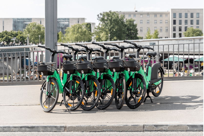 Række af grønne dele-elcykler parkeret i en dansk by