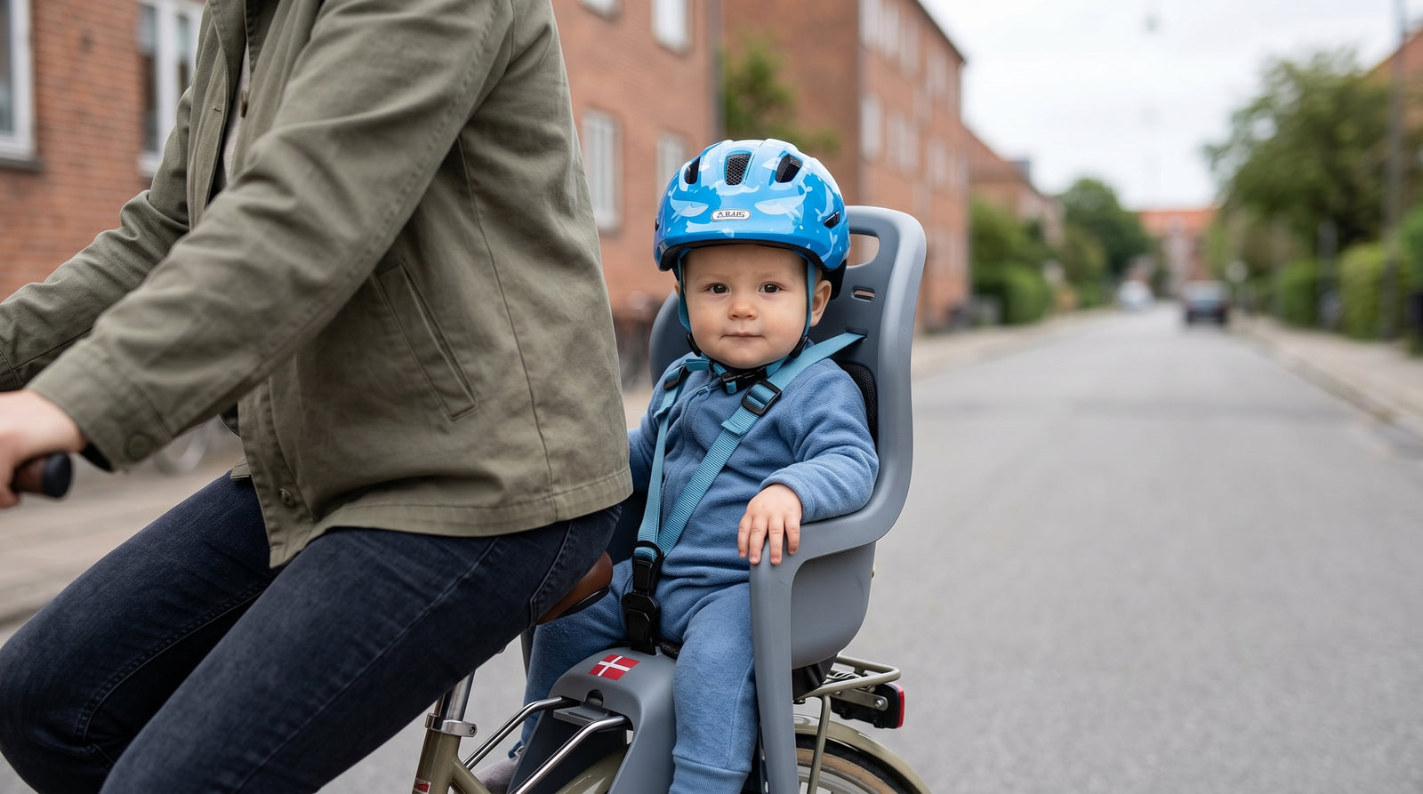 Baby på 10 måneder i barnestol med blå Abus Smiley cykelhjelm, dansk byvej